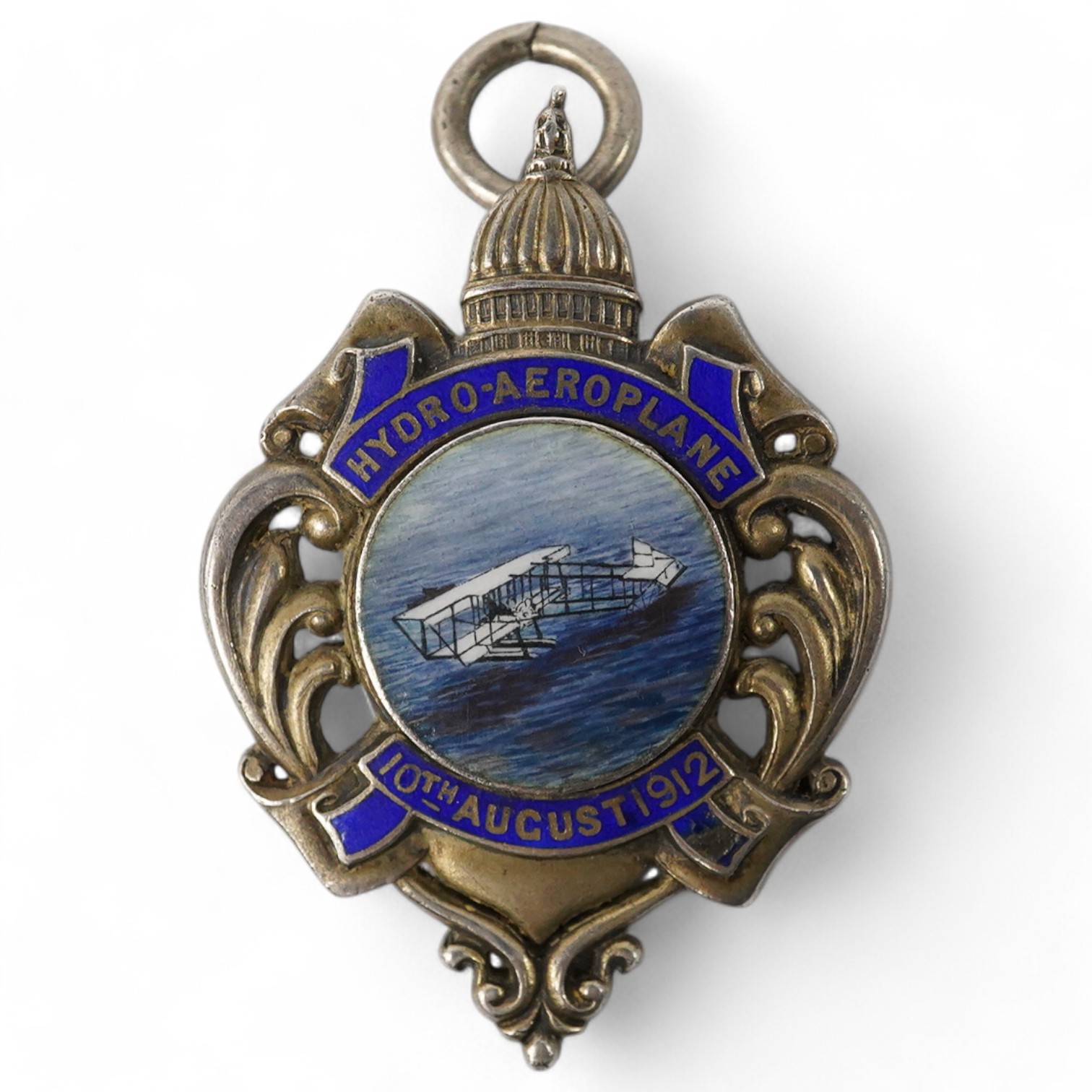 A Naval Air Service History silver and enamel medal by Carrington & Co., London, with an enamel picture of the aircraft to the obverse above the date; 10th August 1912, and with engraving to the reverse commemorating; ‘T